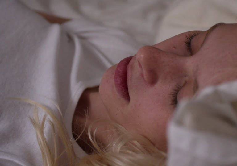 feminist porn Female Fantasy a blonde girl on a white bed in a white t-shirt